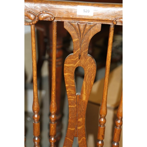 520 - A late 19th century carved oak spindle back elbow chair with dolphin head top rail and panel seat