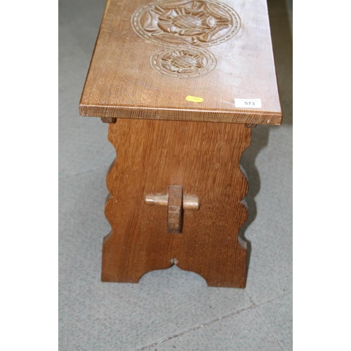 573 - An Arts & Crafts Tudor rose carved oak stool of 17th century design, on panel end supports, 21