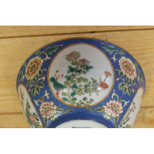 113 - A Chinese famille rose bowl, decorated panels with various flowers on a blue textured glazed ground,... 