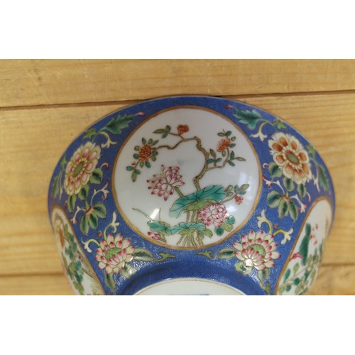 113 - A Chinese famille rose bowl, decorated panels with various flowers on a blue textured glazed ground,... 