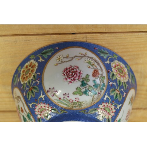 113 - A Chinese famille rose bowl, decorated panels with various flowers on a blue textured glazed ground,... 