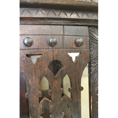 550 - A late Victorian carved oak three-tier revolving bookcase with Gothic pierced sides, 25