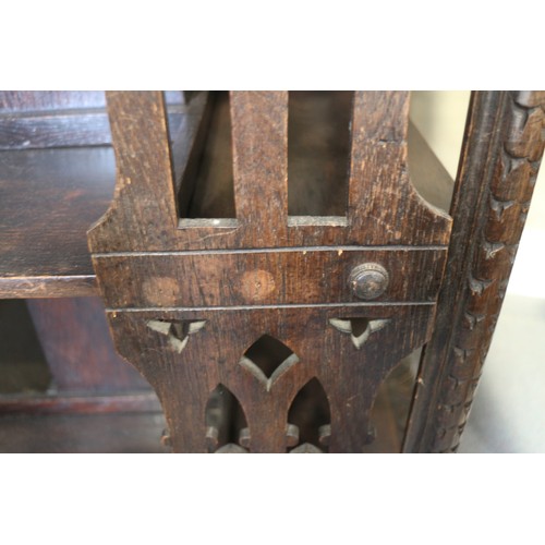 550 - A late Victorian carved oak three-tier revolving bookcase with Gothic pierced sides, 25