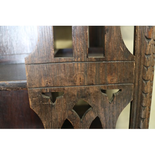 550 - A late Victorian carved oak three-tier revolving bookcase with Gothic pierced sides, 25