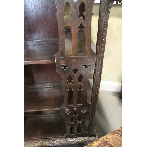 550 - A late Victorian carved oak three-tier revolving bookcase with Gothic pierced sides, 25