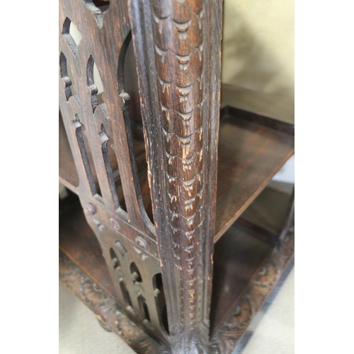 550 - A late Victorian carved oak three-tier revolving bookcase with Gothic pierced sides, 25