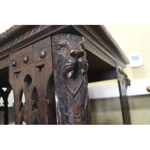 550 - A late Victorian carved oak three-tier revolving bookcase with Gothic pierced sides, 25