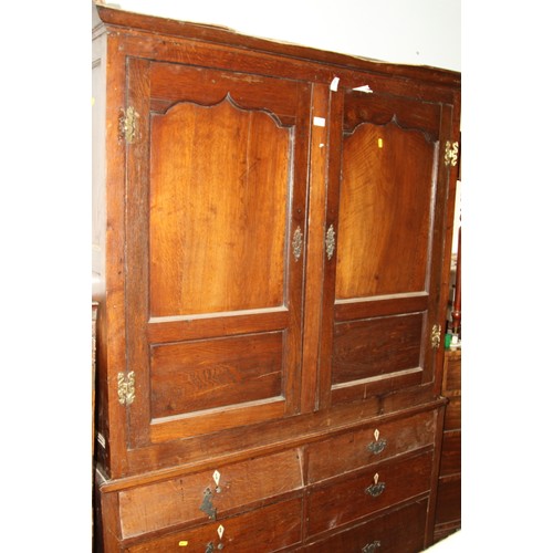 517 - An 18th century oak wardrobe, the upper section enclosed two Gothic panel doors over two faux drawer... 