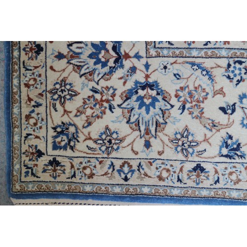 699 - A Persian Nain rug, finely woven with all-over floral design on a blue ground and multi-bordered in ... 