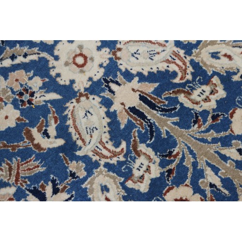 699 - A Persian Nain rug, finely woven with all-over floral design on a blue ground and multi-bordered in ... 