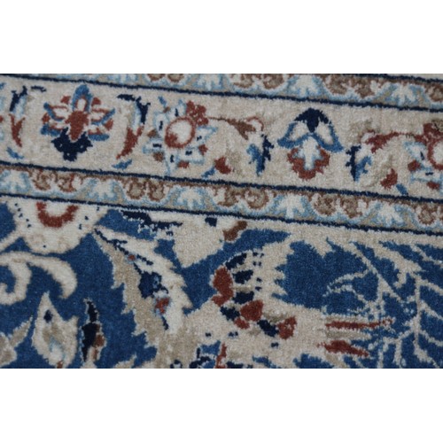 699 - A Persian Nain rug, finely woven with all-over floral design on a blue ground and multi-bordered in ... 