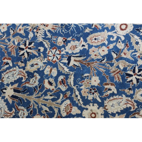 699 - A Persian Nain rug, finely woven with all-over floral design on a blue ground and multi-bordered in ... 