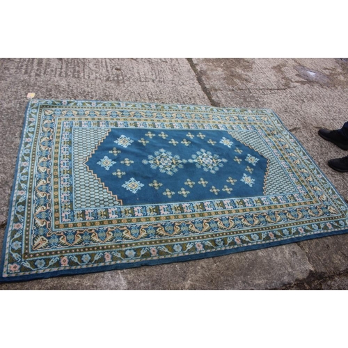 742 - A Caucasian rug of traditional design with two central medallions on a blue ground in shades of gree... 