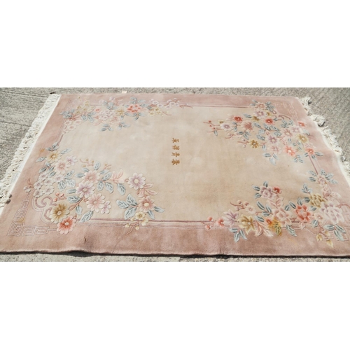 750 - A Chinese wool contour pile rug with floral design and character centre, 67