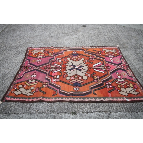 743 - A kelim rug of traditional geometric design with star medallion on an orange ground, 95