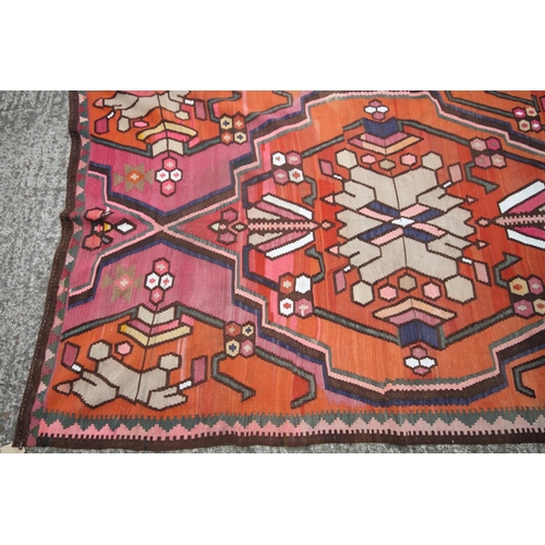 743 - A kelim rug of traditional geometric design with star medallion on an orange ground, 95