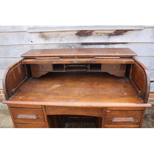 521 - A 19th century oak roll top desk with fitted interior over nine drawers with slides, block base, 42