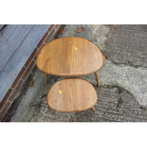 569 - Two Ercol light elm pebble tables, larger: 19 1/2