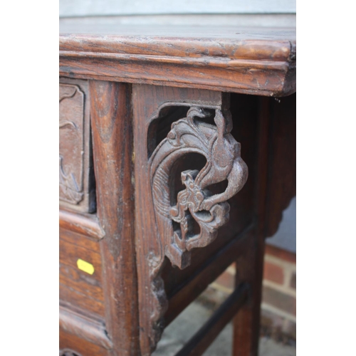610 - A Chinese carved elm side table, fitted two drawers, on turned supports, 39