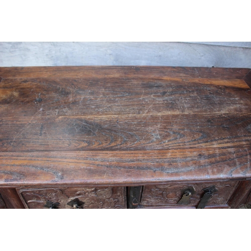 610 - A Chinese carved elm side table, fitted two drawers, on turned supports, 39