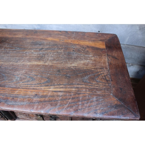 610 - A Chinese carved elm side table, fitted two drawers, on turned supports, 39