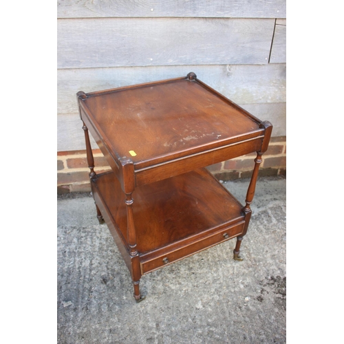 613 - A mahogany two-tier lamp table, fitted one drawer, on turned and castored supports, 18