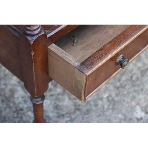 613 - A mahogany two-tier lamp table, fitted one drawer, on turned and castored supports, 18