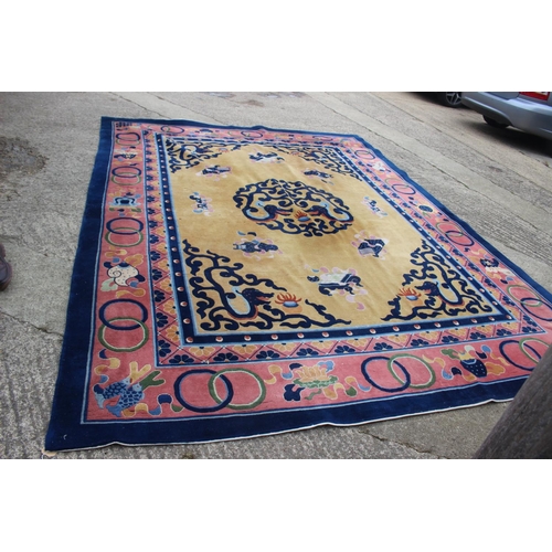 664 - A Chinese contour pile carpet of traditional design with sacred objects on an old gold ground, 114