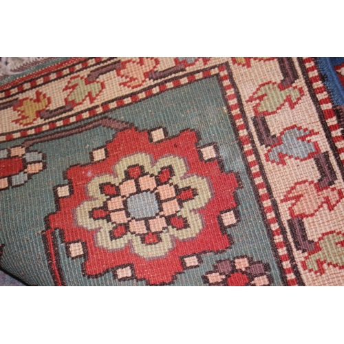 668 - A Kazak style rug with all-over geometric design on a red ground with floral borders, in shades of r... 