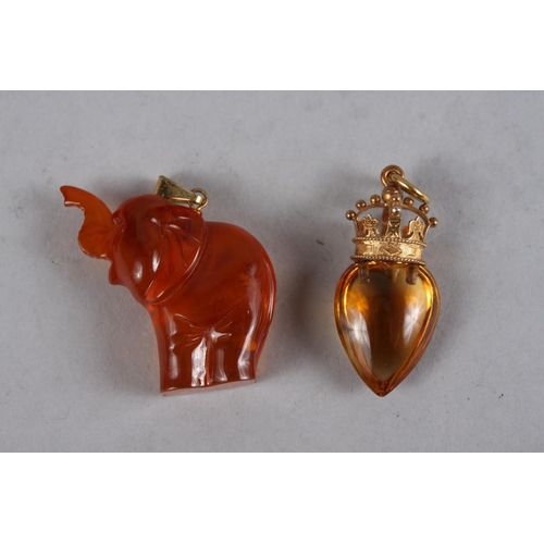 312 - An amber pendant with yellow metal coronet mounts, an amber pebble necklace, a carved amber elephant... 