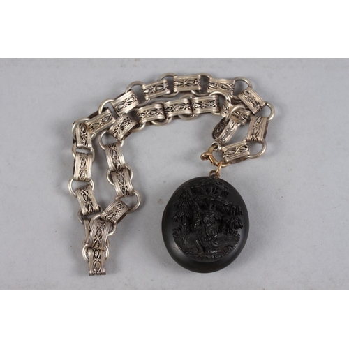 318 - A Victorian white metal fancy link collar with a carved Whitby jet locket, decorated in high relief ... 