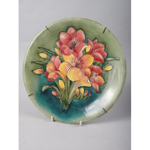 1 - A Moorcroft plate, decorated pink freesias on a green ground, 10 1/4