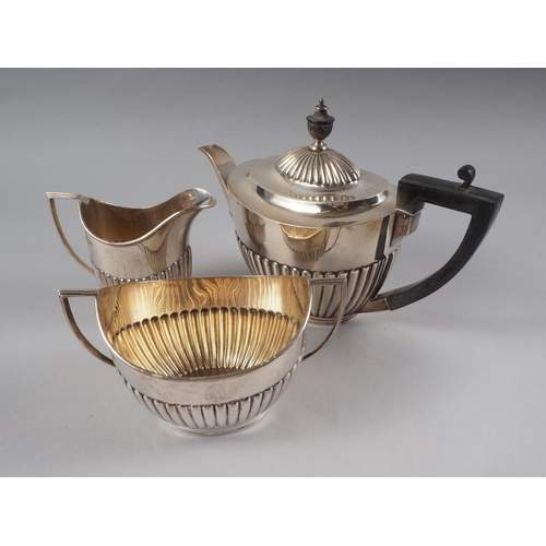 270 - A silver half-fluted three-piece teaset with composition handle, 25oz troy approx