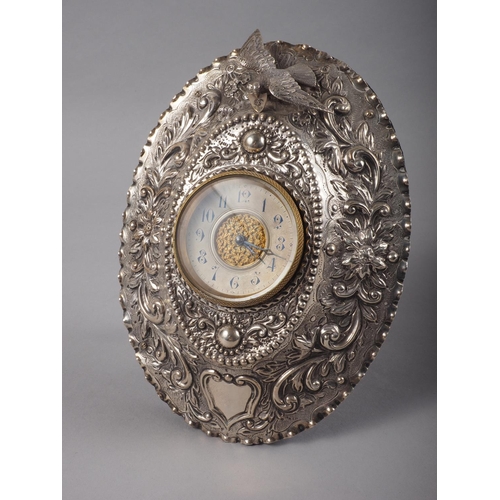 296 - An embossed easel clock with bird and scroll decoration, 7 1/4