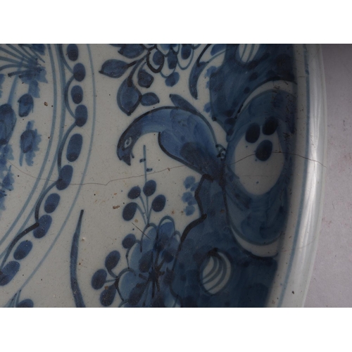 30 - An 18th century Dutch Delft blue and white glazed charger with bird, plant and flower decoration, 13... 