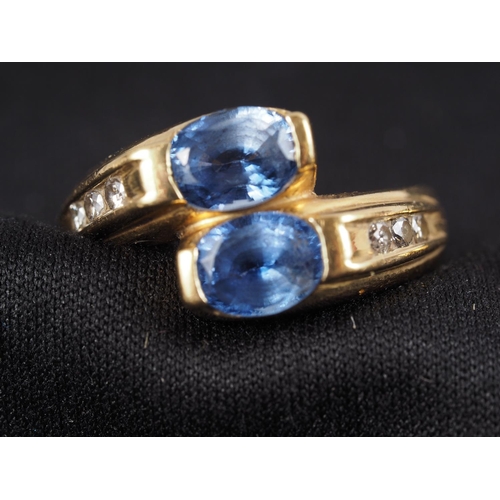 309 - A yellow metal, stamped 750, two Sri Lankan sapphires and diamond set crossover ring, size M, and a ... 