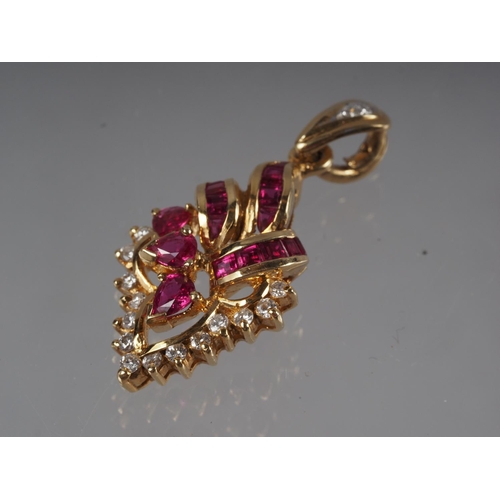 336 - A Thai yellow metal scrollwork pendant, stamped 750, set rubies and diamonds, 4.3g gross