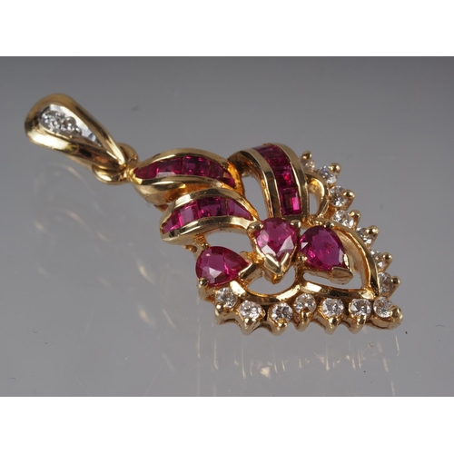 336 - A Thai yellow metal scrollwork pendant, stamped 750, set rubies and diamonds, 4.3g gross