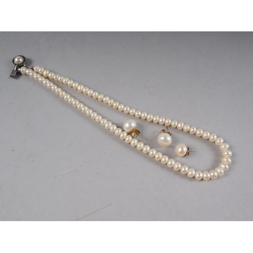 355 - A baroque pearl single-strand necklace (approx seventy-five) with white metal clasp and three pearl ... 