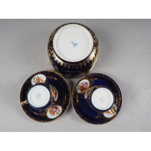 47 - A pair of Vienna cabinet cups and saucers, decorated panels with figures in a landscape on a blue gr... 