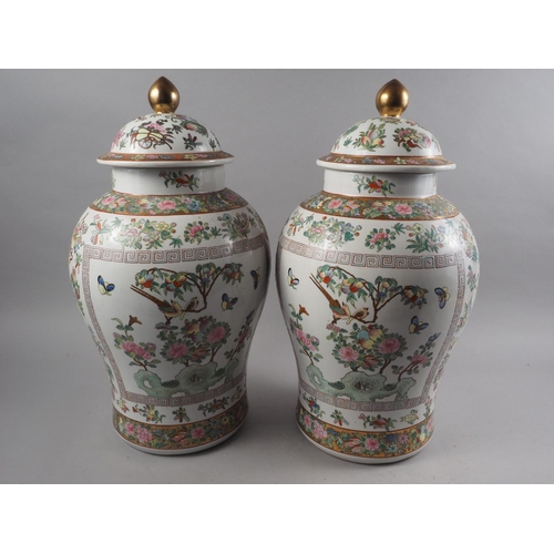 79 - A pair of Chinese baluster shaped vases and covers with polychrome flower, fruit, bird insect and th... 