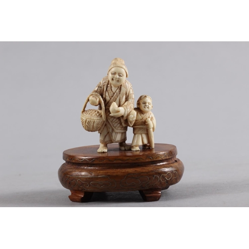 121 - An early 20th century carved ivory figure group/netsuke woman and child, 2