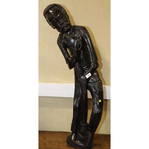 222 - An African carved and ebonised hardwood figure of a man with an axe, 38 1/2