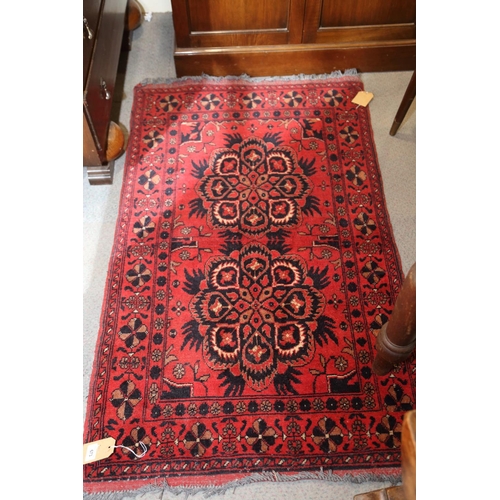 673 - A Persian tribal rug with two star medallions on a red ground, 29 1/2