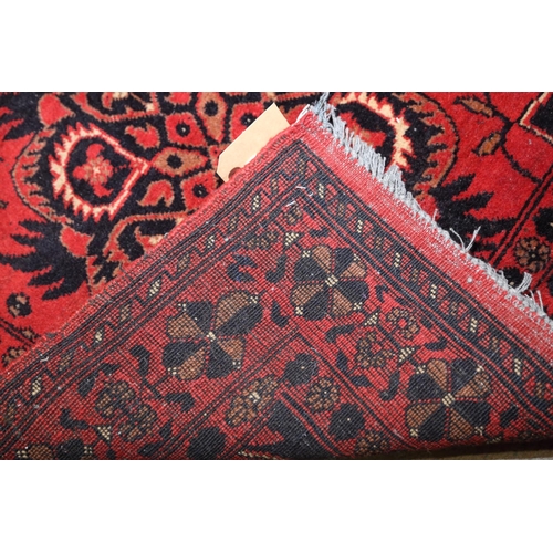 673 - A Persian tribal rug with two star medallions on a red ground, 29 1/2