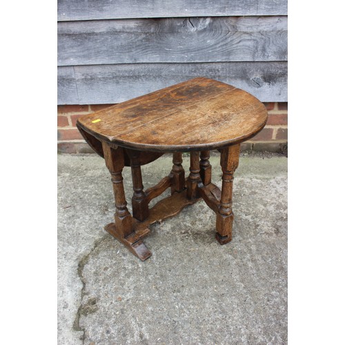 600 - An oak oval drop leaf low occasional table, on gate leg support, 21