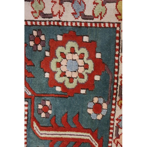 668 - A Kazak style rug with all-over geometric design on a red ground with floral borders, in shades of r... 