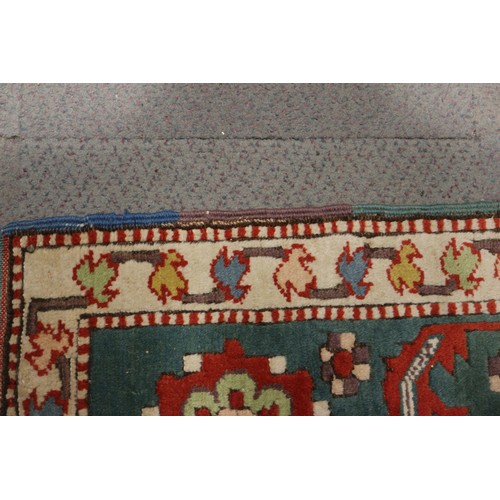 668 - A Kazak style rug with all-over geometric design on a red ground with floral borders, in shades of r... 