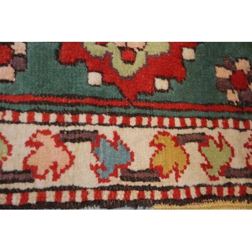 668 - A Kazak style rug with all-over geometric design on a red ground with floral borders, in shades of r... 