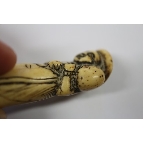 117 - A Japanese carved antler netsuke, formed as a Dutchman holding a ham hock, 2 1/4